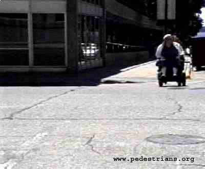 Photo - wheelchair user at single diagonal curb cut
