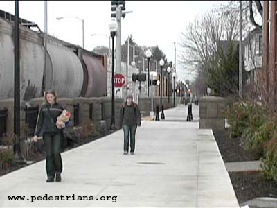 Wide pedestrian/bicycle roadway next to a railroad.