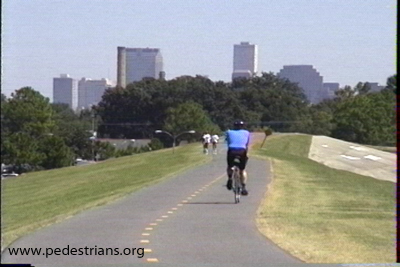 bicyclists and pedestrians on levee trail.