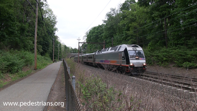 Train on track next to paved trail.